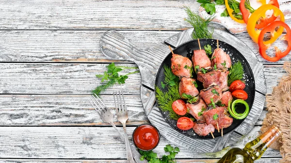 Skewers with vegetables. Kebab in a black plate. Top view. Free copy space.