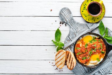 Shakshuka domates ve sebze ile çırpılmış yumurta. Kahvaltı. Tabakta. Üst te. Düz döşeme kompozisyonU Ücretsiz kopyalama alanı.