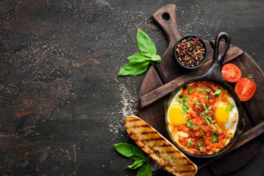 Shakshuka domates ve sebze ile çırpılmış yumurta. Kahvaltı. Tabakta. Üst te. Düz döşeme kompozisyonU Ücretsiz kopyalama alanı.
