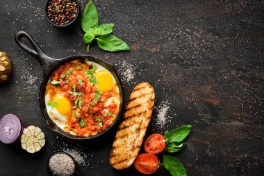 Shakshuka domates ve sebze ile çırpılmış yumurta. Kahvaltı. Tabakta. Üst te. Düz döşeme kompozisyonU Ücretsiz kopyalama alanı.