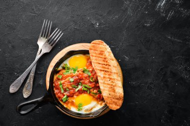 Shakshuka domates ve sebze ile çırpılmış yumurta. Kahvaltı. Tabakta. Üst te. Düz döşeme kompozisyonU Ücretsiz kopyalama alanı.