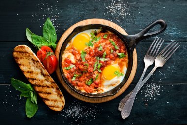 Shakshuka domates ve sebze ile çırpılmış yumurta. Kahvaltı. Tabakta. Üst te. Düz döşeme kompozisyonU Ücretsiz kopyalama alanı.