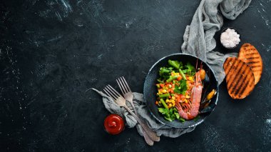 Sebzeli deniz ürünleri. Karides ve midye ile haşlanmış sebze. Siyah bir tabakta. Üst te. Ücretsiz kopyalama alanı.