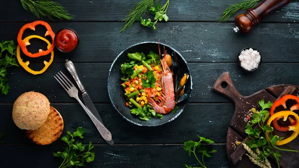 海鲜与蔬菜 用虾和贝类煮蔬菜 在一块黑盘子里顶部视图 免费复制空间 — 图库照片