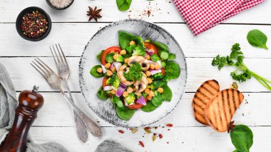 Salata mantar, ıspanak, Türk bezelye ve soğan ahşap bir arka plan üst görünümü üzerinde bir tabak ta. Metniniz için boş alan. Düz yatıyordu