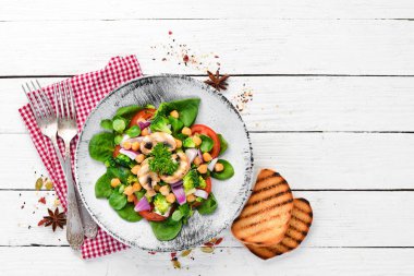 Salata mantar, ıspanak, Türk bezelye ve soğan ahşap bir arka plan üst görünümü üzerinde bir tabak ta. Metniniz için boş alan. Düz yatıyordu