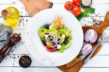 Yunan salatası. Beyaz peynir, zeytin ve kiraz domates ile sebze salatası. Tabakta. Üst te. Metniniz için boş alan. Rustik stil.