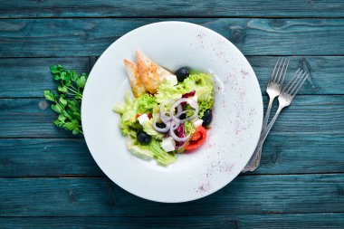 Yunan salatası. Beyaz peynir, zeytin ve kiraz domates ile sebze salatası. Tabakta. Üst te. Metniniz için boş alan. Rustik stil.