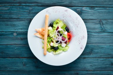 Yunan salatası. Beyaz peynir, zeytin ve kiraz domates ile sebze salatası. Tabakta. Üst te. Metniniz için boş alan. Rustik stil.