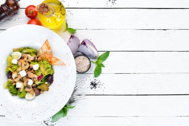 Mantar, zeytin ve beyaz peynir ile sebze salatası. Tabakta. Üst te. Metniniz için boş alan. Rustik stil.