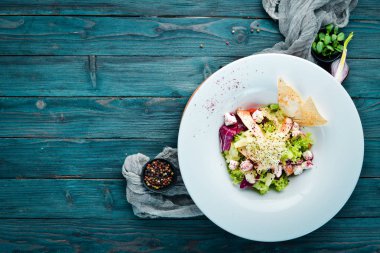 Tavuk fileto, ananas ve beyaz peynir ile sebze salatası. Tabakta. Üst te. Metniniz için boş alan. Rustik stil.