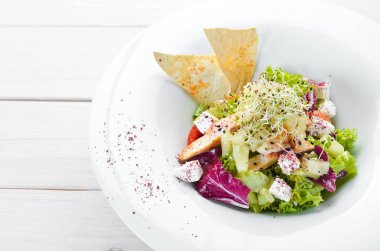 Tavuk fileto, ananas ve beyaz peynir ile sebze salatası. Tabakta. Üst te. Metniniz için boş alan. Rustik stil.