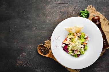 Tavuk fileto, ananas ve beyaz peynir ile sebze salatası. Tabakta. Üst te. Metniniz için boş alan. Rustik stil.