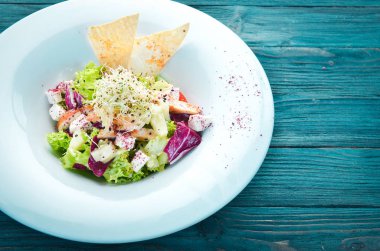 Tavuk fileto, ananas ve beyaz peynir ile sebze salatası. Tabakta. Üst te. Metniniz için boş alan. Rustik stil.