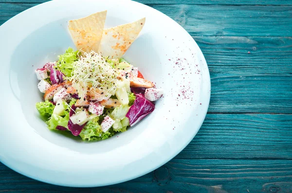 Tavuk fileto, ananas ve beyaz peynir ile sebze salatası. Tabakta. Üst te. Metniniz için boş alan. Rustik stil.