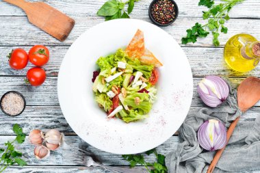 Peynirli sebze salatası, zeytin ve çeri domates. Tabakta. Üst te. Metniniz için boş alan. Rustik stil.