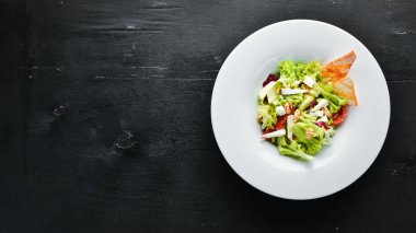 Peynirli sebze salatası, zeytin ve çeri domates. Tabakta. Üst te. Metniniz için boş alan. Rustik stil.