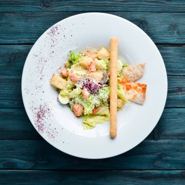 Somonlu sebzeli Sezar salatası. Tabakta. Üst te. Metniniz için boş alan. Rustik stil.