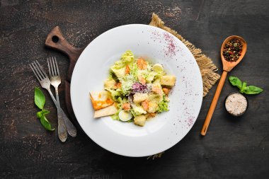 Somonlu sebzeli Sezar salatası. Tabakta. Üst te. Metniniz için boş alan. Rustik stil.