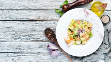 Somonlu sebzeli Sezar salatası. Tabakta. Üst te. Metniniz için boş alan. Rustik stil.