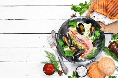 Deniz ürünleri yle pirinç. Karides ve midye ile Risotto. Siyah bir tabakta. Üst te. Ücretsiz kopyalama alanı.