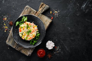 Haşlanmış pirinç ve sebze. Risotto Siyah bir tabakta. Üst te. Ücretsiz kopyalama alanı.