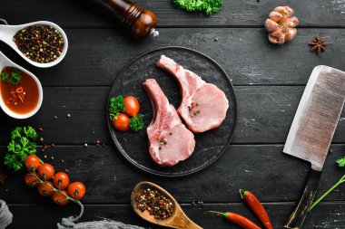 Kemikte çiğ domuz bifteği var. Bir tabak baharat ve ot. Üst te. Metniniz için boş alan.