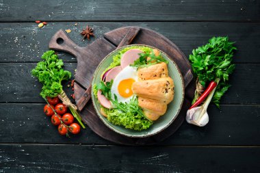 Kızarmış yumurta ve sosis, domates ve soğan ile kruvasan sandviç. Üst te. Metniniz için boş alan.