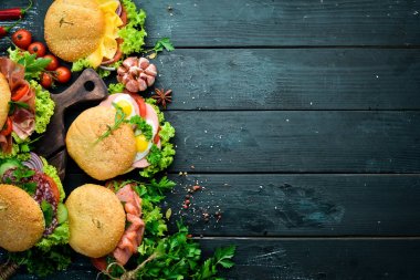 Et, peynir, balık ve sebze ile hamburger seti. Siyah bir arka plan üzerinde. Üst te. Metniniz için boş alan.