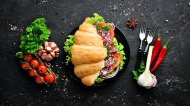 Salam, domates ve soğan ile kruvasan. Kahvaltı. Üst te. Metniniz için boş alan.