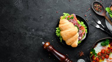 Salam, domates ve soğan ile kruvasan. Kahvaltı. Üst te. Metniniz için boş alan.