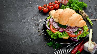 Salam, domates ve soğan ile kruvasan. Kahvaltı. Üst te. Metniniz için boş alan.