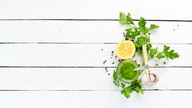Yeşil maydanoz sosu, chimichurri sos için malzemeler. Beyaz ahşap bir arka plan üzerinde. Üst te. sizin için boş alan 
