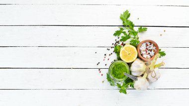 Yeşil maydanoz sosu, chimichurri sos için malzemeler. Beyaz ahşap bir arka plan üzerinde. Üst te. sizin için boş alan 
