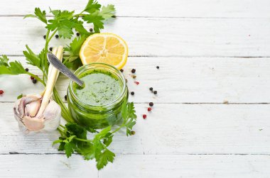 Yeşil maydanoz sosu, chimichurri sos için malzemeler. Beyaz ahşap bir arka plan üzerinde. Üst te. sizin için boş alan 