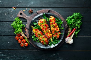 Patlıcanlar siyah bir tabaktabakta sebze ile pişirilir. Üst te. Metniniz için boş alan.