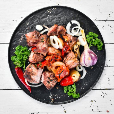 Tabakta kebap. Soğan ve domates ile pişmiş et. Barbekü. Üst te. Metniniz için boş alan. Rustik stil.