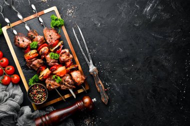 Soğan ve domates ile şiş kebap Barbekü et. Siyah bir arka plan üzerinde. Üst te. Metniniz için boş alan. Rustik stil.