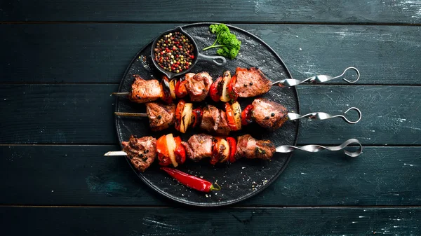 Soğan ve domates ile şiş kebap Barbekü et. Siyah bir arka plan üzerinde. Üst te. Metniniz için boş alan. Rustik stil.