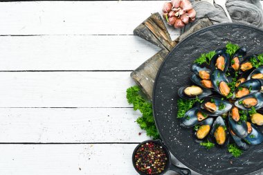 Siyah bir tabakta maydanoz ve baharat ile haşlanmış midye. Üst te. Metniniz için boş alan.