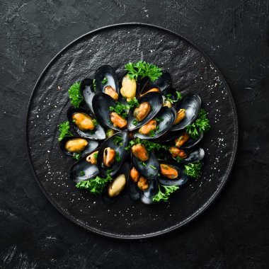 Siyah bir tabakta maydanoz ve baharat ile haşlanmış midye. Üst te. Metniniz için boş alan.