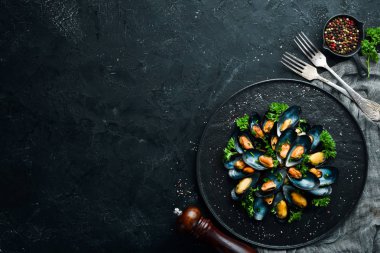 Siyah bir tabakta maydanoz ve baharat ile haşlanmış midye. Üst te. Metniniz için boş alan.