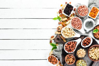 Beyaz ahşap arka plan üzerinde çeşitli fındık. Üst te. Metniniz için boş alan.