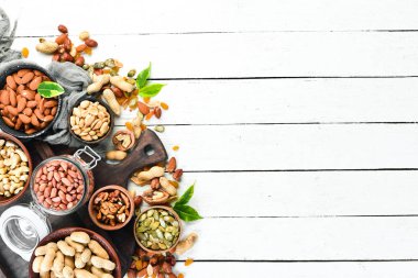 Beyaz ahşap arka plan üzerinde çeşitli fındık. Üst te. Metniniz için boş alan.