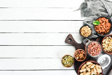 Beyaz ahşap arka plan üzerinde çeşitli fındık. Üst te. Metniniz için boş alan.