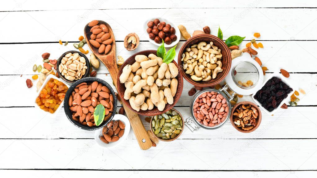 Assorted nuts on a white wooden background. Top view. Free space for your text.