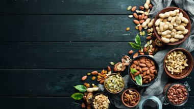 Eski siyah arka plan üzerinde çeşitli fındık. Üst te. Metniniz için boş alan.