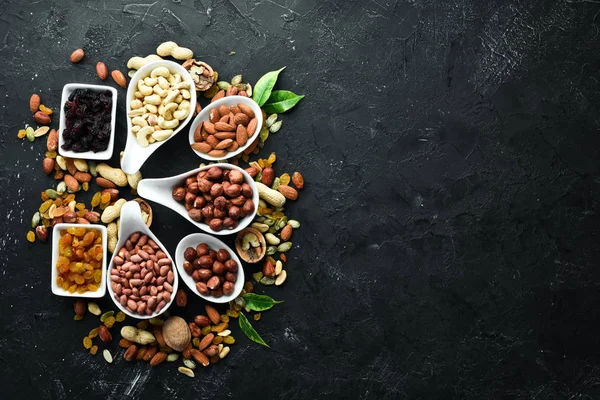 Eski siyah arka plan üzerinde çeşitli fındık. Üst te. Metniniz için boş alan.