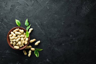 Siyah bir arka plan üzerinde yer fıstığı. Fındık Üst görünümü. Metniniz için boş alan.