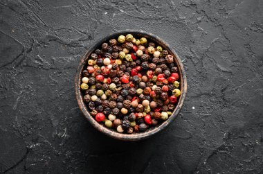 Siyah bir arka plan üzerinde Biber bezelye Baharatlar. Üst te. metniniz için boş alan.